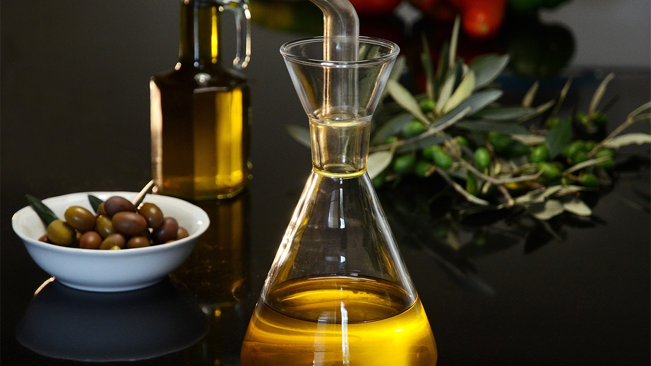 Aceite de oliva virgen extra y aceitunas sobre una mesa