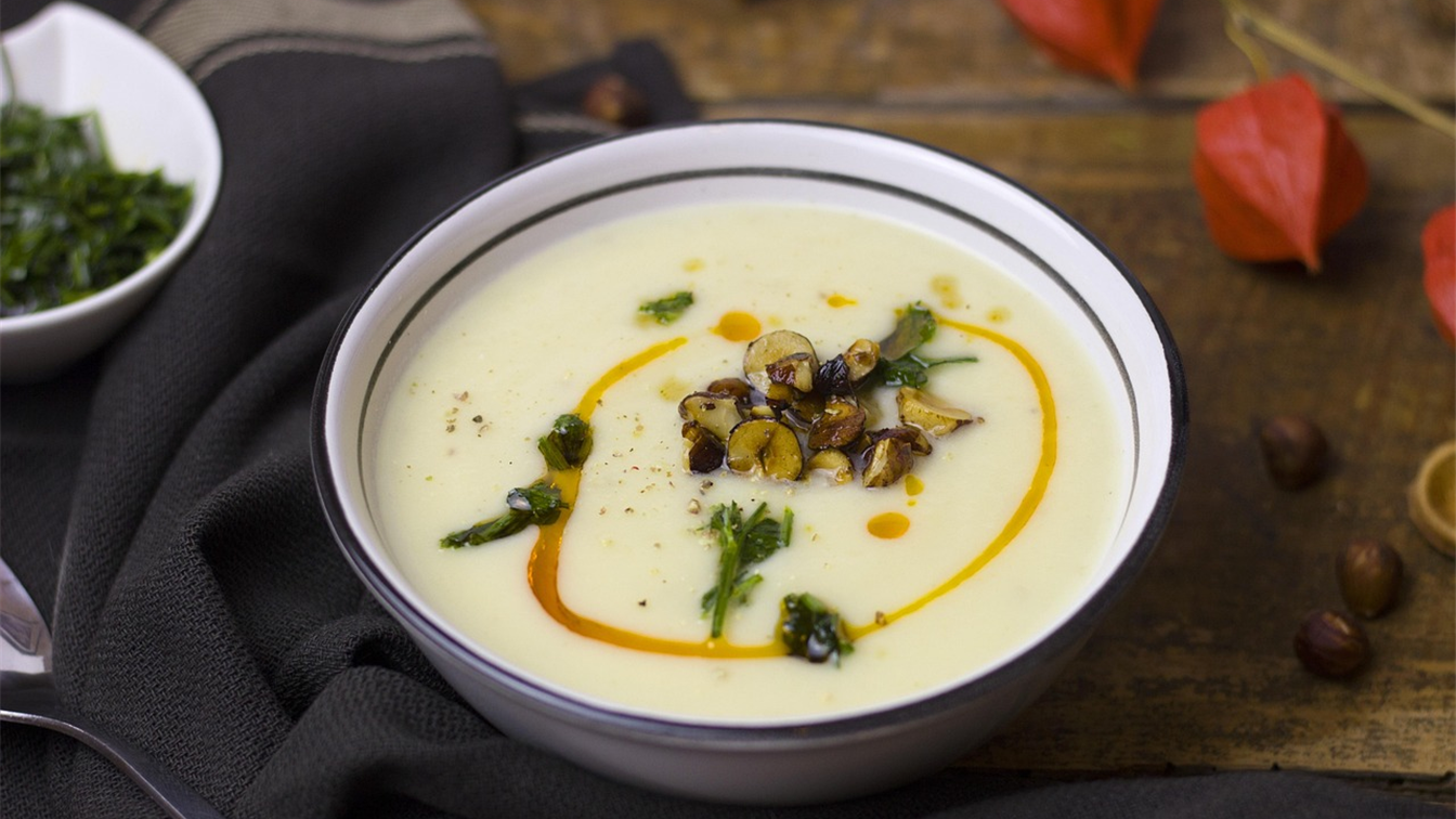 Crema de verduras de otono en un bol sobre una mesa de madera